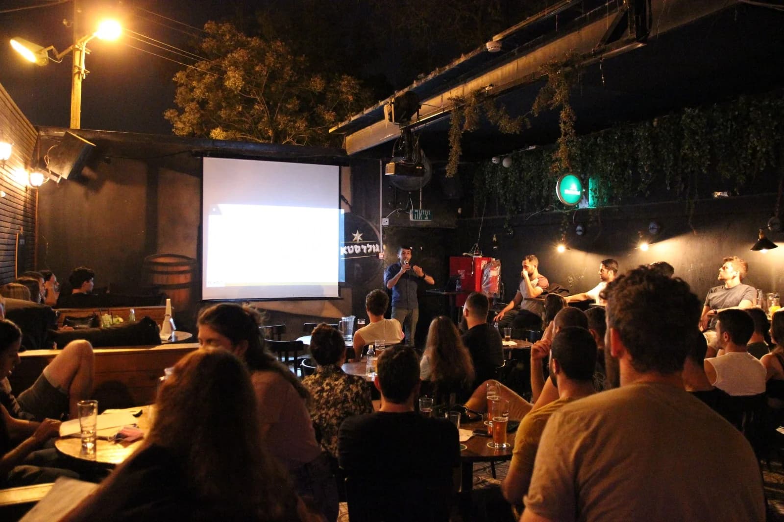 Dani speaking to a seated audience at an evening event